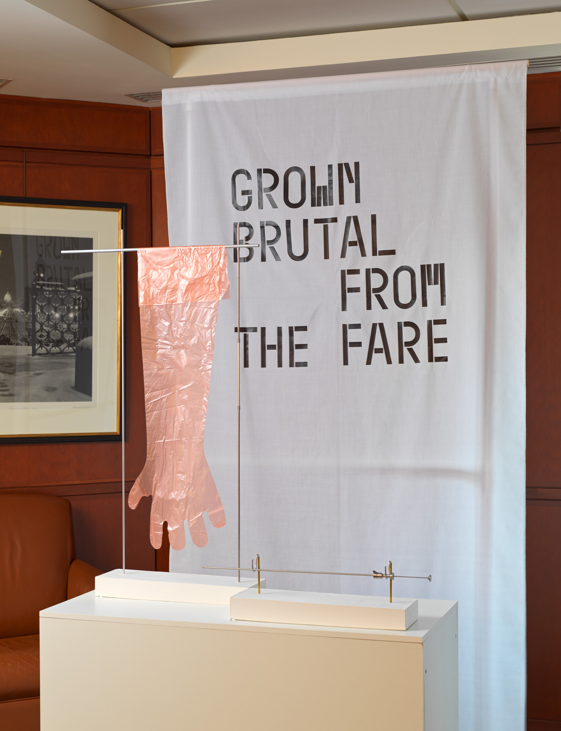 A display of an artificial insemination glove with a banner behind it