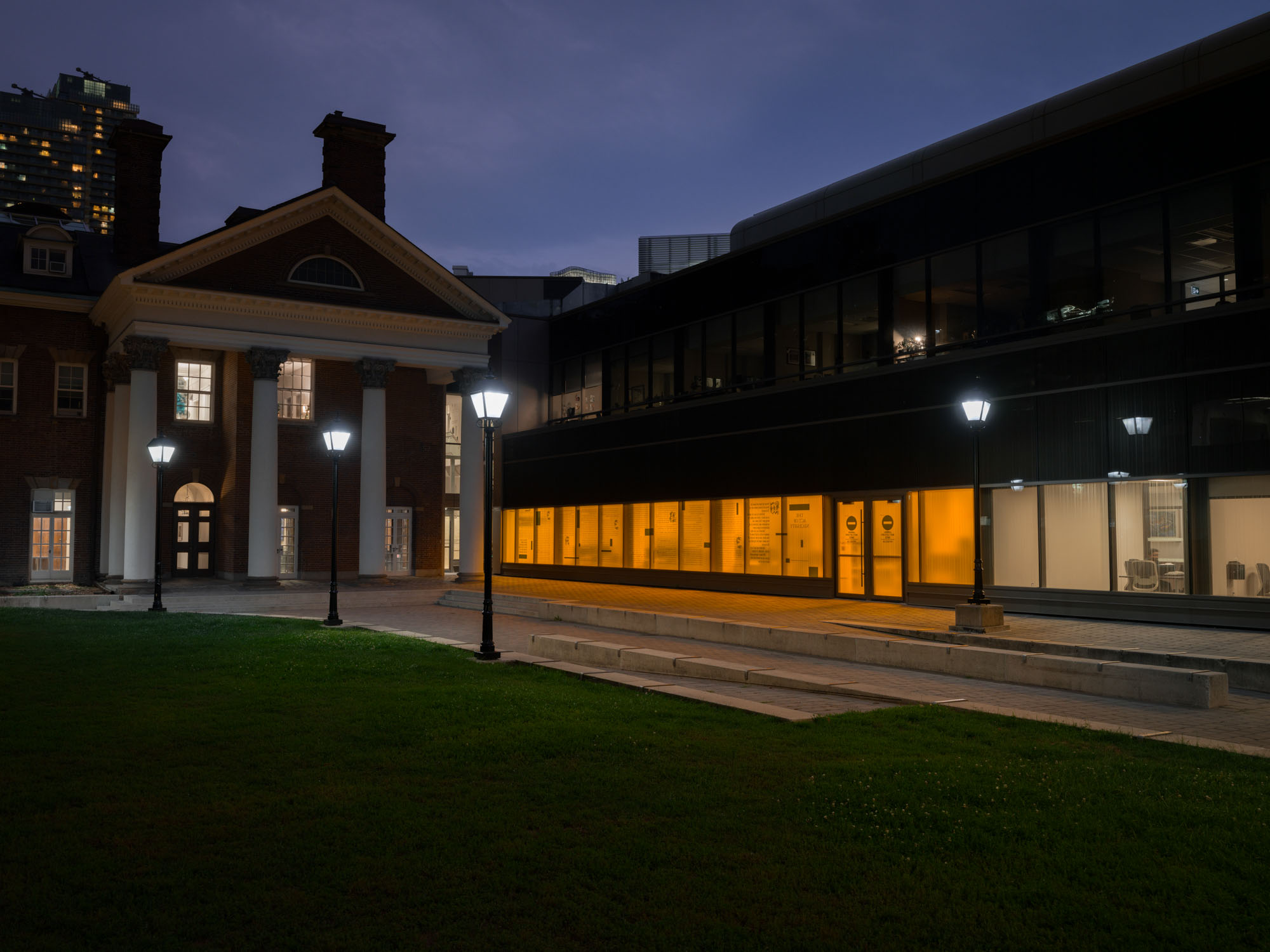 Looking into the Bora Laskin Law Library information commons with The Act of Necessity text window vinyl installation at night.